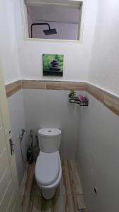 a bathroom with a white toilet with a window at LANISCA'S Home in Yaoundé