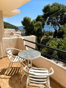 a patio with a table and chairs on a balcony at FILOXENIA by Evita's Resort in Poros