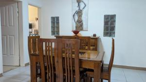 a dining room with a wooden table and chairs at LANISCA'S Home in Yaoundé