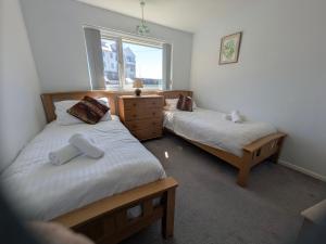 a bedroom with two beds and a window at Surf View Apartments in Newquay +5 photos