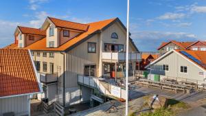 a building with an orange roof next to houses at Seglarhotellet Käringön in Käringön
