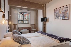a bedroom with two beds and a table and a window at Seglarhotellet Käringön in Käringön +12 photos
