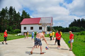 un grupo de personas jugando al fútbol en una cancha de baloncesto en Guesthouse Leiputrija, en Ādaži
