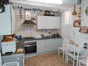 a kitchen with white cabinets and a stove top oven at La casita de la vito in Illar