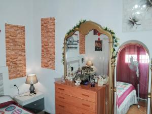 a bedroom with a dresser and a mirror at La casita de la vito in Illar