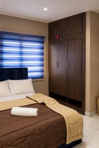a bedroom with a large bed and a large window at Caligeo Suites I in Ibadan