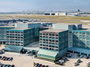an airport building with cars parked in a parking lot at Sheraton Gateway Hotel in Toronto International Airport in Mississauga