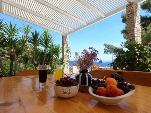 a table with two bowls of fruit and a glass of juice at Seaside Apartments Sunny Prižba in Blato