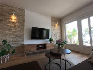 a living room with a tv on a brick wall at Seaside Apartments Sunny Prižba in Blato