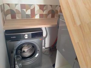 a washer and dryer under a wooden table at La petite maison in Marchampt