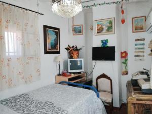 a bedroom with a bed and a desk with a television at La casita de la vito in Illar