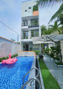 a swimming pool with an inflatable raft in front of a building at May Bliss Villa in Danang