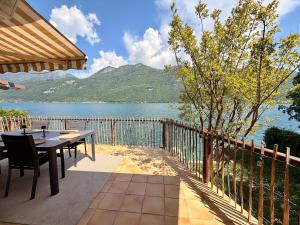 a patio with a table and a view of a lake at La cabane les pieds dans l'eau, accès direct au lac d'Annecy in Doussard +28 photos