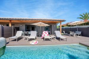 a deck with chairs and a swimming pool and a house at Résidence Pierre & Vacances Premium Vesna Rossa in Porto-Vecchio