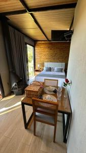 a bedroom with a bed and a table with a table sidx sidx sidx at Cabana Chácara Vilagio daspedras in Nova Petrópolis