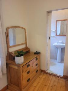 a bathroom with a dresser with a mirror and a sink at Muizenberg Surfers Lodge in Muizenberg +19 photos