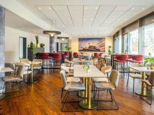 a restaurant with tables and chairs in a room with windows at ibis Berlin Mitte in Berlin