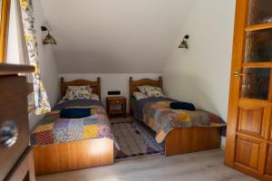 a bedroom with two beds and a door open at Domek Leśny Anioł in Jarnołtówek