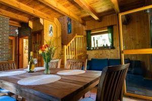 a dining room with a wooden table and chairs at Domek Leśny Anioł in Jarnołtówek