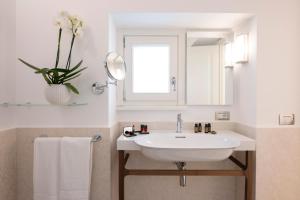 a bathroom with a sink and a vase with flowers at Bambagina Mare in Amalfi