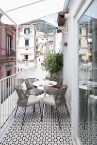 a patio with a table and chairs on a balcony at Bambagina Mare in Amalfi +30 photos