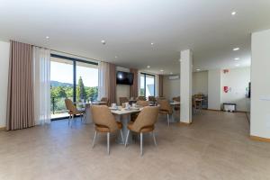 a conference room with a table and chairs and windows at Lima Riverview Suites in Ponte de Lima