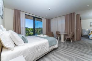a hotel room with a large bed and a table with chairs at Lima Riverview Suites in Ponte de Lima +110 photos