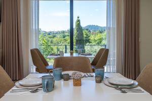 a dining room with a table and a large window at Lima Riverview Suites in Ponte de Lima