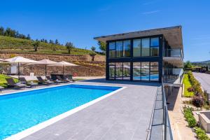 a villa with a swimming pool and a house at Lima Riverview Suites in Ponte de Lima