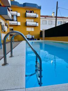 a swimming pool with a metal rail next to a building at Casa Oceano 59 in Costa da Caparica