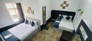 a bedroom with two beds and a window at Hotel Bougainvillea in Cochin