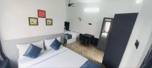 a bedroom with a bed with blue and white pillows at Hotel Bougainvillea in Cochin
