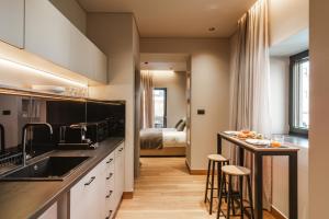 a kitchen with a sink and a counter with stools at Grava Aurum - City Suites in Igoumenitsa