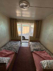 a bedroom with two beds and a window at All Home in Cholpon-Ata