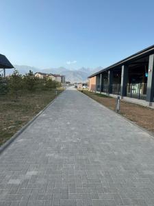 an empty sidewalk in front of a building at All Home in Cholpon-Ata +9 photos