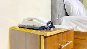 a desk with a hair dryer on top of a bed at H&Ts Bars and Hotels in Ibadan