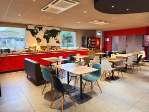 a restaurant with tables and chairs and a counter at ibis Rennes Cesson in Cesson-Sévigné