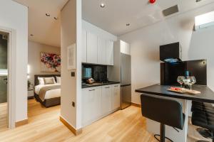 a kitchen and living room with a bed in a room at Grava Aurum - City Suites in Igoumenitsa
