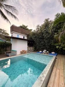 a swimming pool in front of a house at Pousada Caraíva in Caraíva