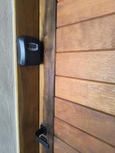 a clock on the side of a wooden door at Guaraú Surf House Chalés in Peruíbe +29 photos