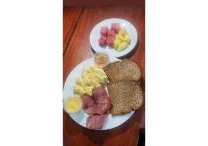 two plates of breakfast food with eggs sausage and bread at Elida Lodge Monteverde in Monteverde Costa Rica +48 photos