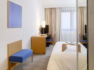 ein Hotelzimmer mit zwei Betten und einem Schreibtisch in der Unterkunft Novotel Gdansk Centrum in Danzig + 70 Fotos
