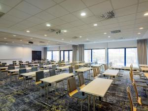 ein Klassenzimmer mit Tischen und Stühlen in einem Raum mit Fenstern in der Unterkunft Novotel Gdansk Centrum in Danzig