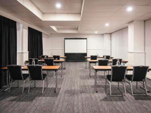 a conference room with tables and chairs and a screen at ibis Styles Mt Isa Verona in Mount Isa +40 photos