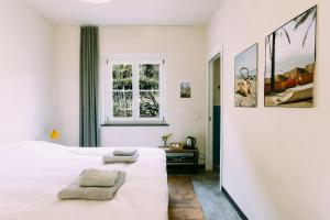 a bedroom with a white bed and a window at Agriturismo Valleponci in Finale Ligure