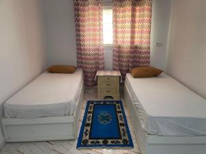 a room with two beds and a window at Cozy Retreat in Bou Ficha