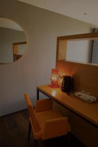 a room with a desk with a chair and a mirror at Le Petit Létraz in Duingt