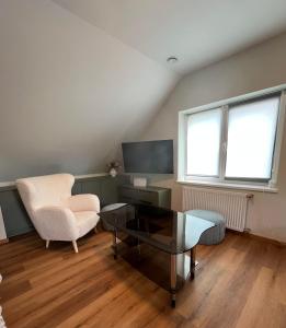 a living room with a chair and a table and a tv at Melnragė Dunes Apartment in Melnragė
