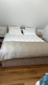 a white bed with white sheets and pillows at Melnragė Dunes Apartment in Melnragė