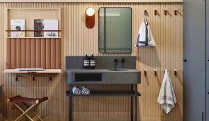 ein Badezimmer mit Waschbecken, Spiegel und Stuhl in der Unterkunft Little Something Hotel NYC in New York